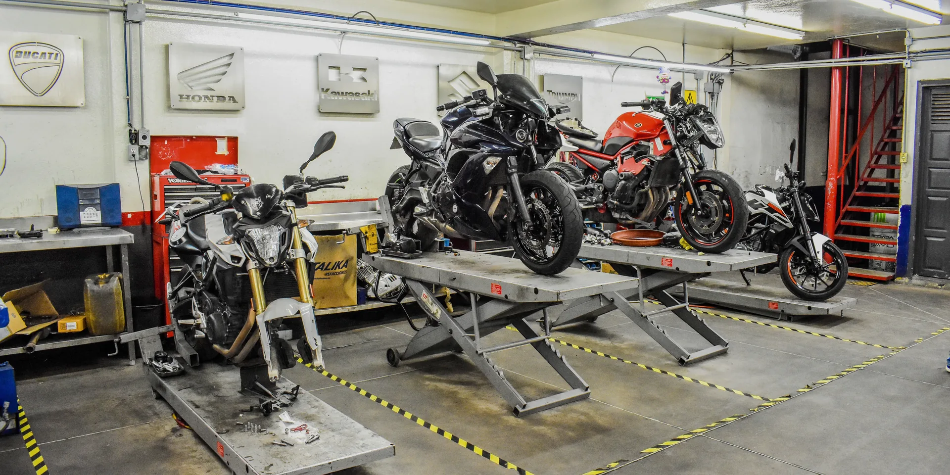 Motorcycle technicians examining a bike for damage and repair requirements